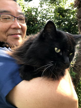 黒猫のリキと代表の関口雅彦のツーショットです